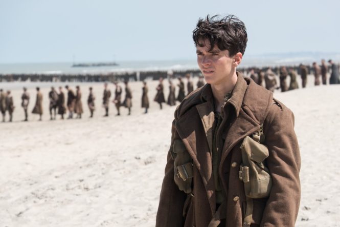 Tommy (Fionn Whitehead) contemplates his rescue options in Dunkirk. Image via .thepicreview.com | Dunkirk movie review | onetakekate.com
